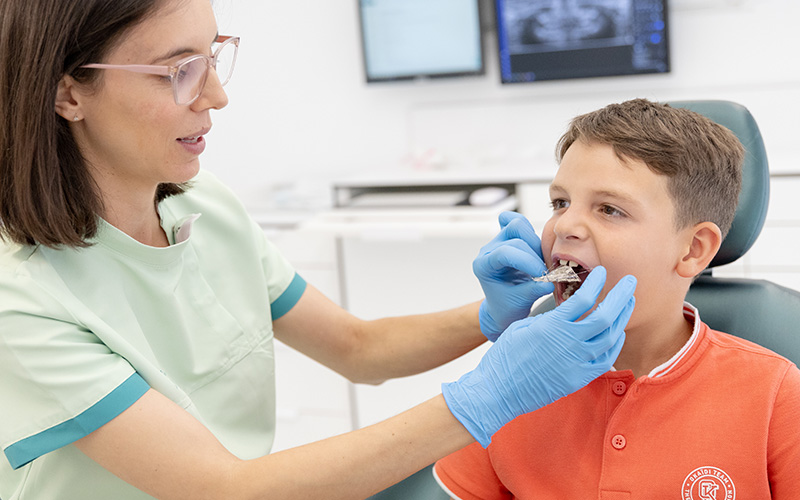 dentista colocando aparato dental infantil